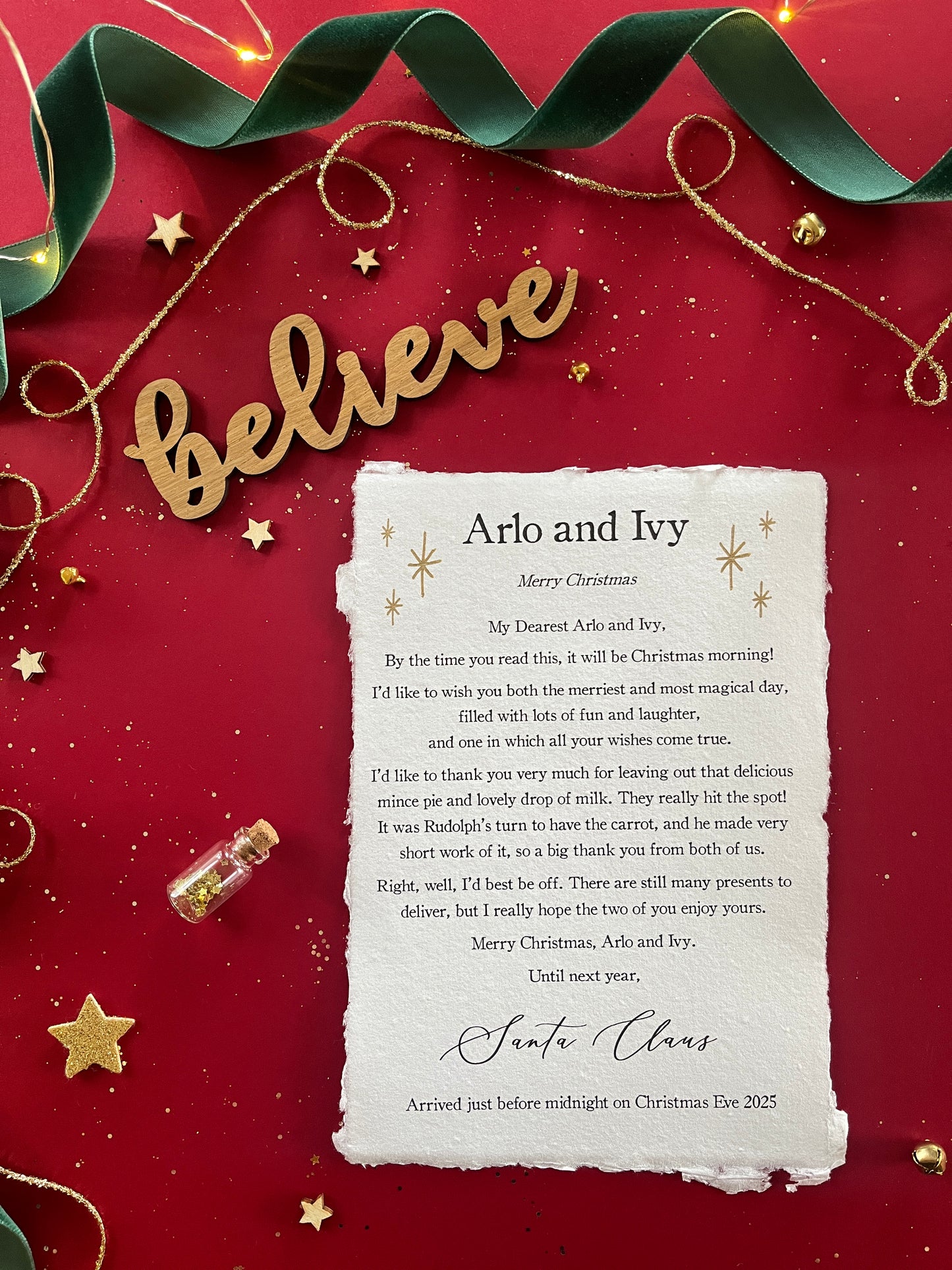 A Christmas morning letter which is entirely personalised with your child's names and unique to them. Finished with Golden stars and details of your Christmas Eve treats for Father Christmas or Santa Claus.
The note, printed on handmade paper, is pictured against a red background with magical decorations.